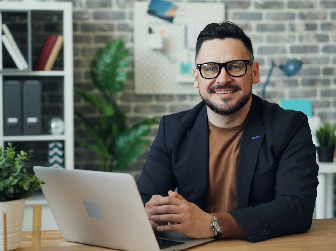 Small business owner smiling at his desk